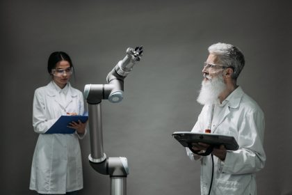 Dois cientistas trabalham com um braço robótico em um laboratório de pesquisa.
