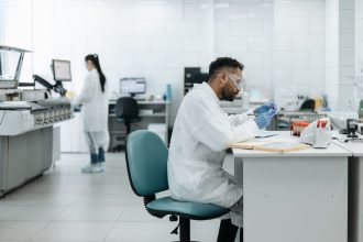 Pesquisadores analisam amostras em um laboratório moderno equipado com tecnologia científica.