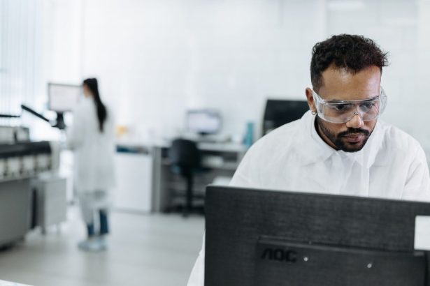 Cientista trabalha em um computador dentro de um laboratório moderno.