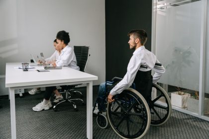Equipe diversa reunida em um escritório, participando de uma discussão sobre inclusão e acessibilidade no trabalho.